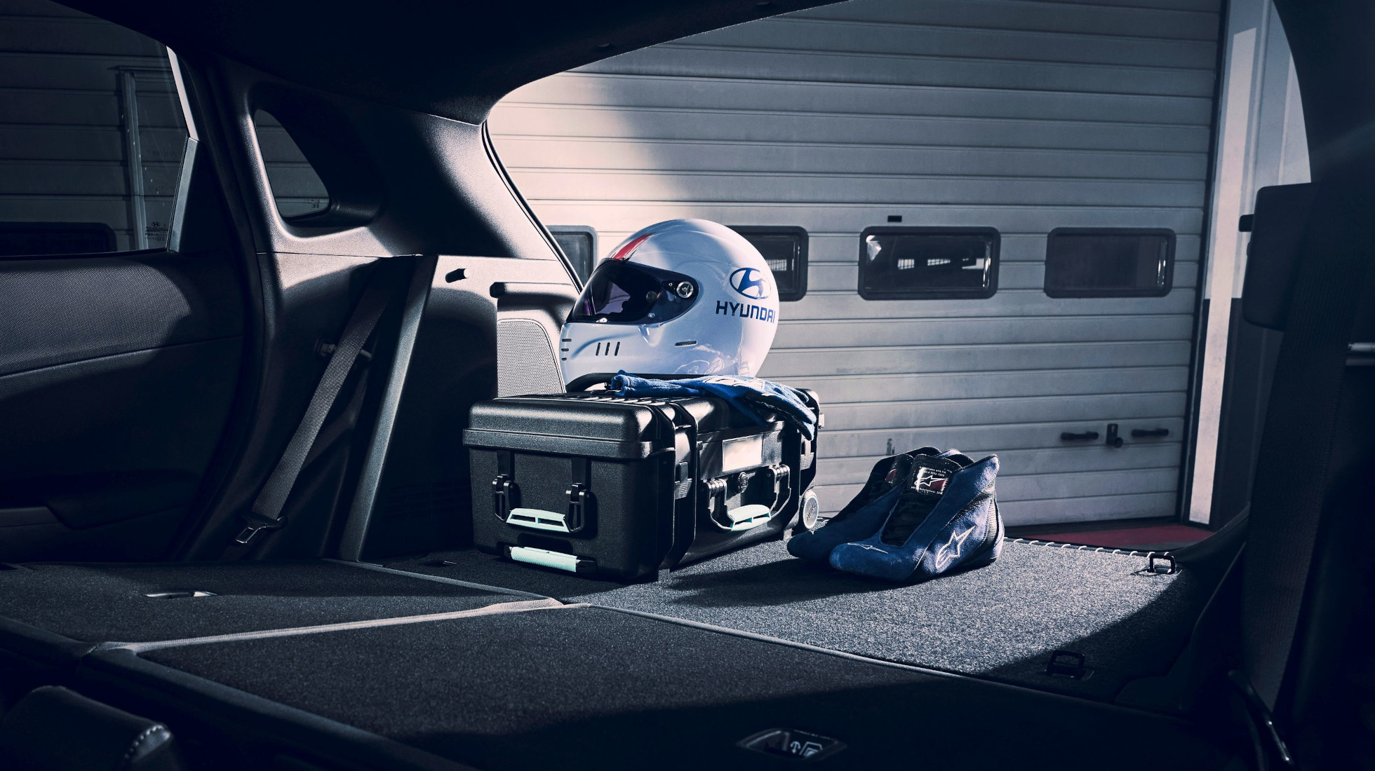 Racing helmet, shoes, and gear stored inside the trunk of the Hyundai KONA N hot SUV.